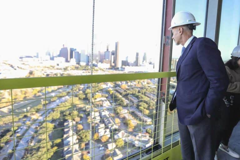 Modern urban skyscraper construction site in Houston with professionals inspecting the view, showcasing Houston EB5 investment opportunities and real estate growth.