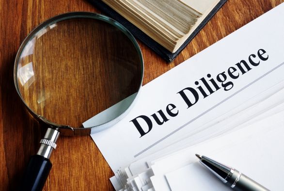 Magnifying glass over due diligence documents for EB-5 investment review