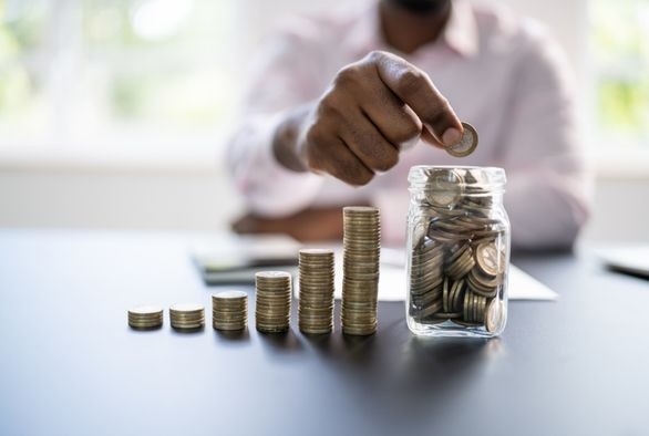 Stacked coins and savings jar illustrating EB-5 source of funds and path of funds documentation