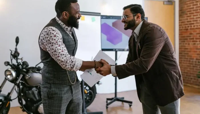 Handshake exchange between two professional men in an office setting, representing Houston EB5 investment opportunities and client relationships.