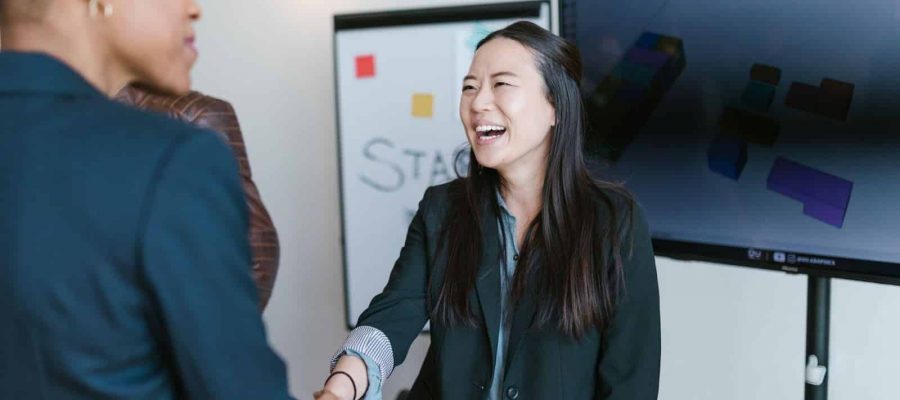 High-angle shot of diverse professionals shaking hands at a business meeting, with a focus on teamwork and success in the Houston EB5 investment opportunity.